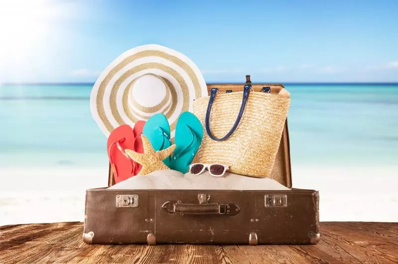old-suitcase-with-accessories-on-beach.jpg